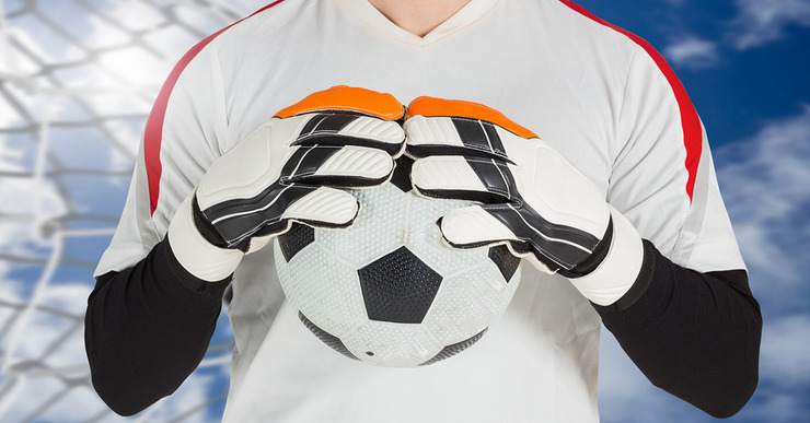 Goalkeeper Holding on to Football