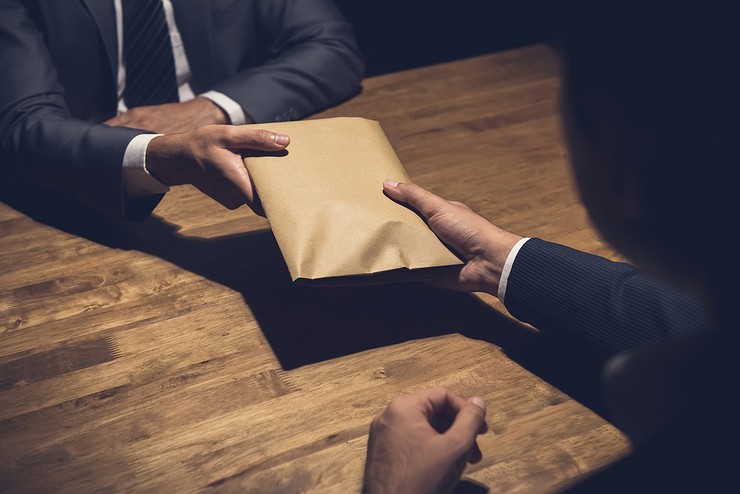 Money Being Passed in Brown Envelope