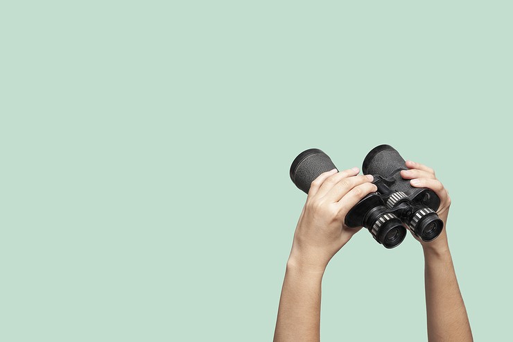 Binoculars Pointing Upwards Against Green Background