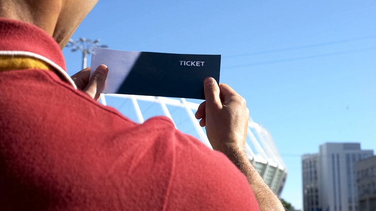 Man Holding Up Football Ticket