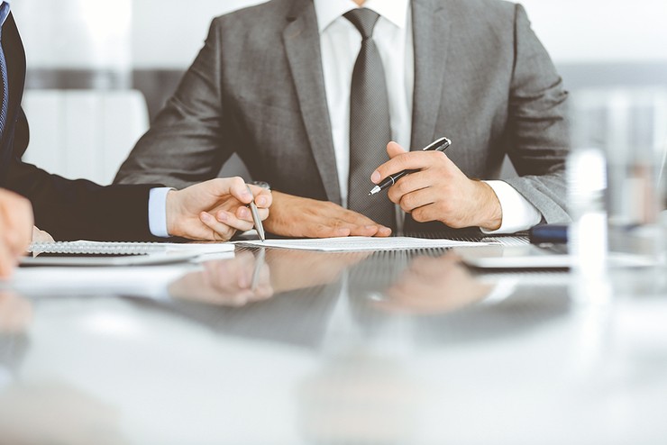 Business People Signing Documents Around Table