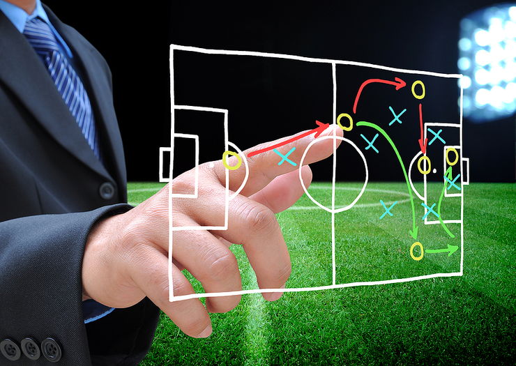Man in Suit Pointing to Drawn Football Tactics