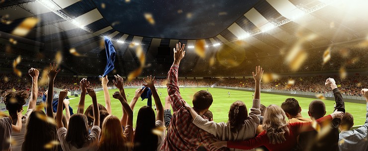 View Behind Football Fans with Arms in the Air