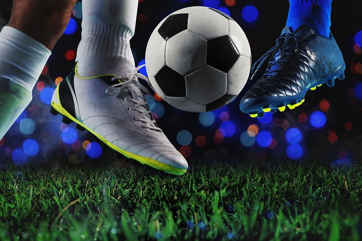 Football Players Contesting Ball Against Coloured Lights