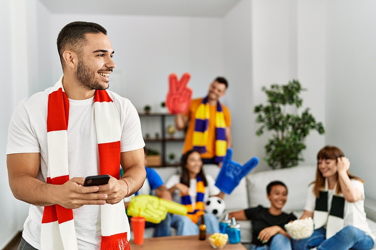 Man Using Phone Watching Football with Friends