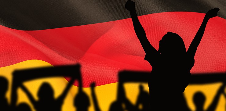 Silhouettes of Football Fans Against German Flag