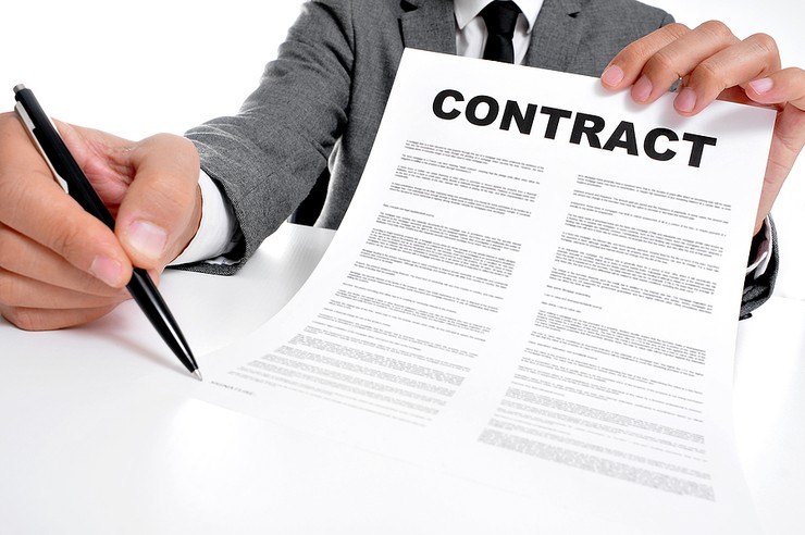 Man in Grey Suit Holding Contract and Pen