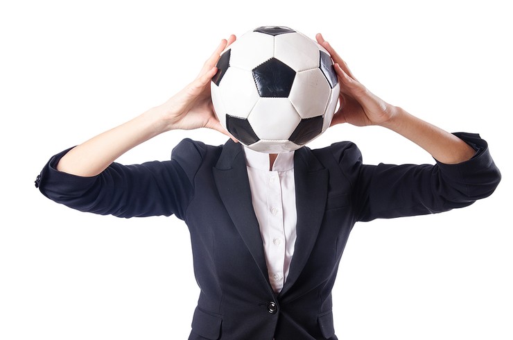 Woman in Suit Holding Football in Front of Face