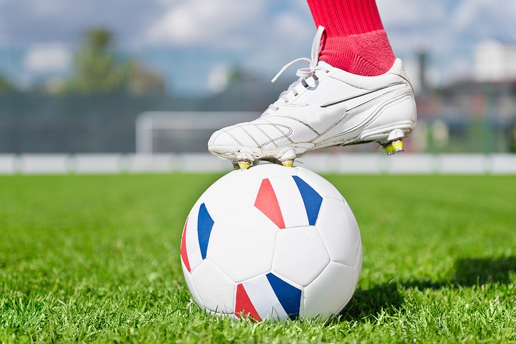 Boot of Footballer on France Flag Panelled Ball